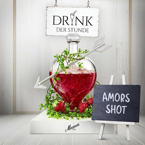 Ein Schild mit der Aufschrift 'DRINK DER STUNDE' hängt über einer dekorativen Flasche, die mit einem Pfeil verziert ist.