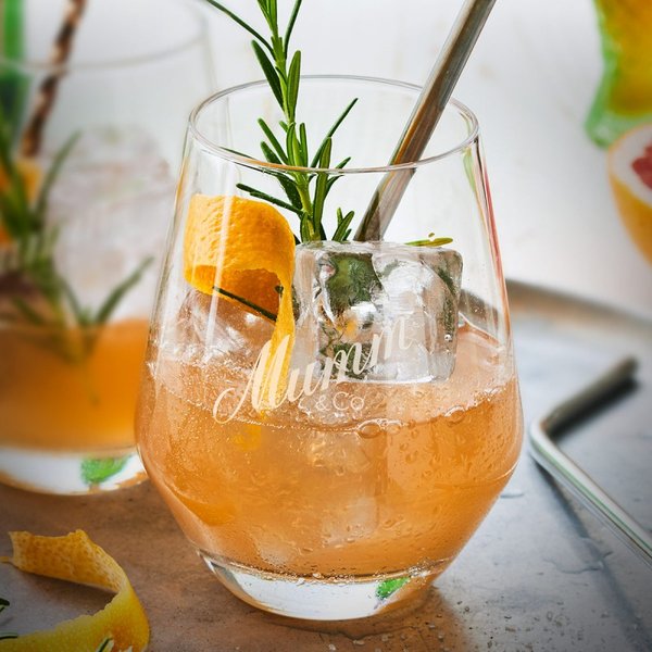 Ein elegantes Glas mit einem erfrischenden Cocktail, garniert mit einem Rosmarinzweig und einer Orangenscheibe.