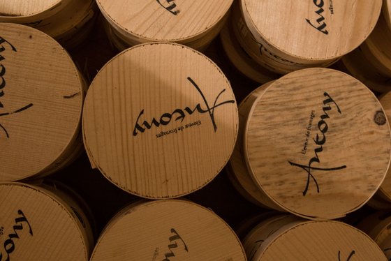 Eine Ansammlung von runden Holzbehältern, die übereinander gestapelt sind, mit dem Schriftzug 'Antony' auf der Oberseite.
