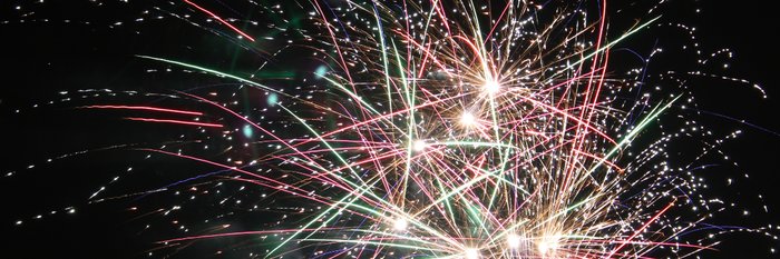 Ein spektakuläres Feuerwerk erhellt den Nachthimmel mit bunten Funken und leuchtenden Strahlen in verschiedenen Farben.
