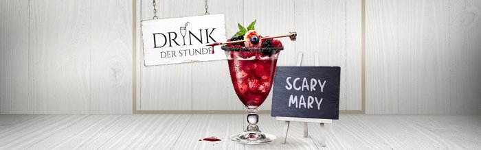 Der 'Scary Mary'-Cocktail in einem stilvollen Glas, umgeben von frischen Früchten und einer dekorativen Tafel.
