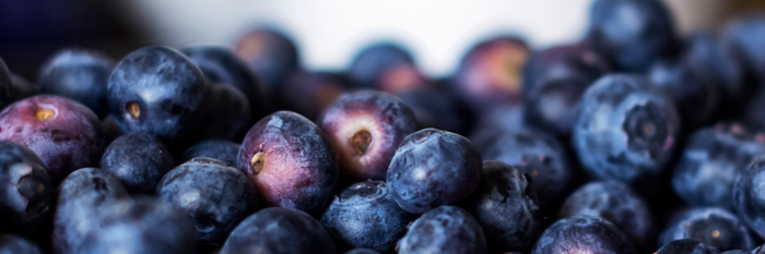 Eine Vielzahl von frischen, saftigen Heidelbeeren, die dicht beieinander liegen und in verschiedenen Blautönen schimmern.