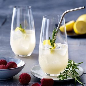 Zwei elegante Gläser mit einem erfrischenden Getränk, garniert mit Zitrone und Rosmarin, stehen auf einem Tisch.