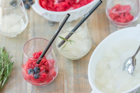 Ein erfrischendes Dessert-Arrangement mit Himbeersorbet und einem klaren gefrorenen Getränk, dekoriert mit Kräutern.