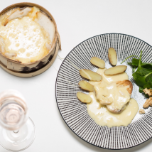 Ein Teller mit zartem Fleisch, umgeben von Kartoffeln und einer cremigen Sauce, garniert mit frischem Salat.