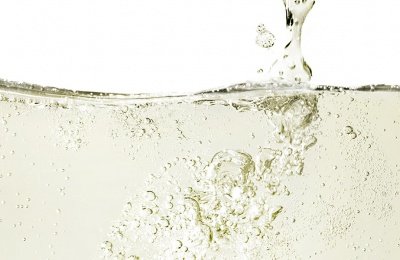 Sprudelndes Wasser mit vielen Blasen, das an der Oberfläche aufsteigt und eine erfrischende Atmosphäre schafft.