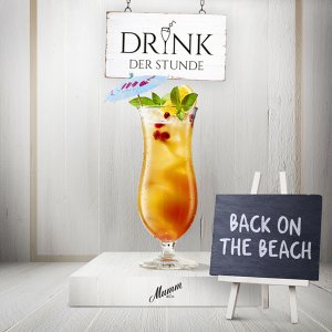 Ein erfrischender Cocktail in einem hohen Glas, dekoriert mit einem kleinen Regenschirm und frischen Minzblättern.