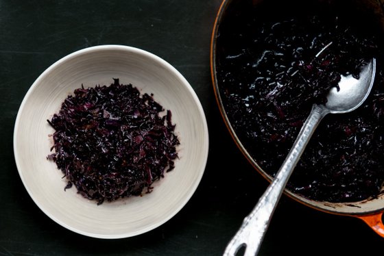 Ein tiefes, dunkles Gericht aus gehacktem Rotkohl, serviert in einer hellen Schüssel auf einer dunklen Oberfläche.