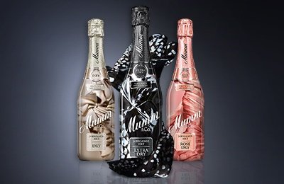 Die Flaschen präsentieren sich in eleganten Farben: Gold, Schwarz und Rosé, umgeben von einem stilvollen schwarzen Tuch.