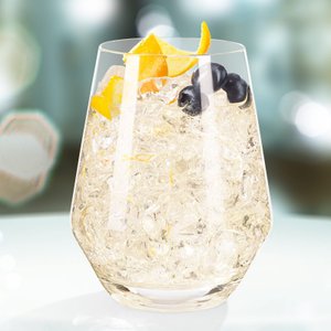 Ein elegantes Glas mit klarem Getränk, gefüllt mit Eis und garniert mit Orangenscheiben und Heidelbeeren.