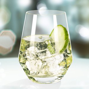 Ein elegantes Glas mit sprudelndem Getränk und Eiswürfeln, garniert mit einer frischen Gurkenscheibe.