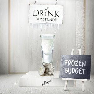 Ein elegantes Glas mit einem klaren Getränk steht auf einem Stapel Münzen, umgeben von einer hellen, minimalistischen Kulisse.